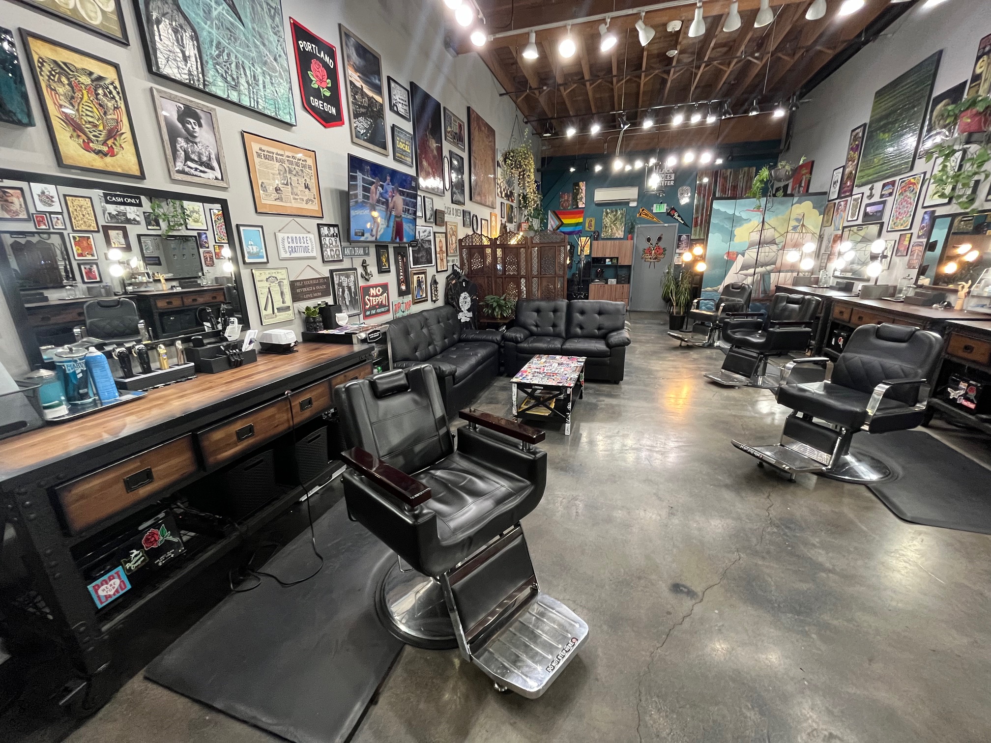Interior of Take Pride Barbershop in Portland OR with barber chairs and wall art