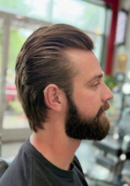 Classic slick-back hairstyle with beard trim by Kenzy at Take Pride Barbershop in Portland.