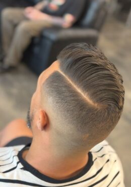 Kenzy at Take Pride Barbershop in Portland giving a men’s skin fade with a hard part line.