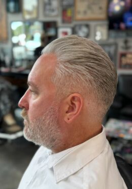 Mature silver slick-back style haircut by Kenzy at Take Pride Barbershop in Portland.