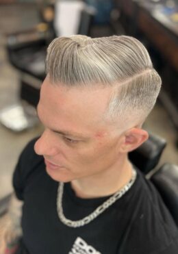 Platinum slick-back fade haircut by Kenzy at Take Pride Barbershop in Portland.